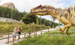Pareja contemplando la estátua de un dinosaurio